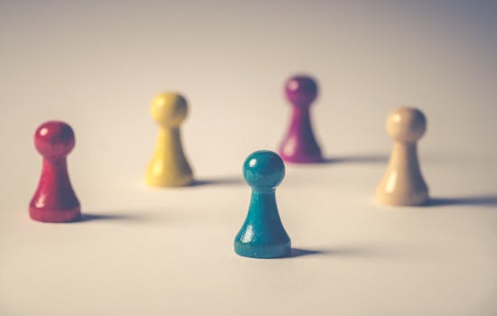 Close-up of colorful board game pawns arranged creatively on white surface.